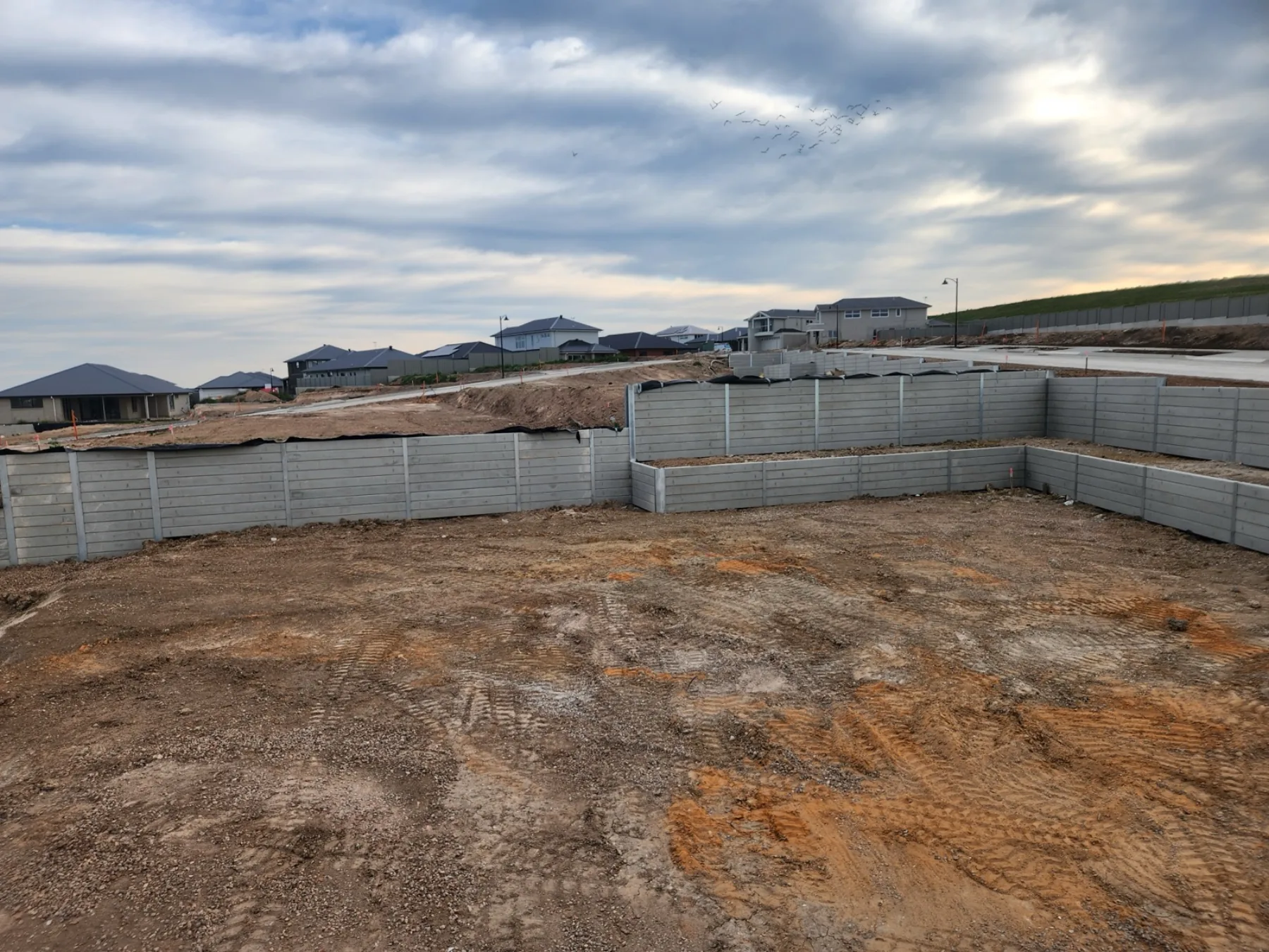 Sleeper retaining wall integrated into a backyard build